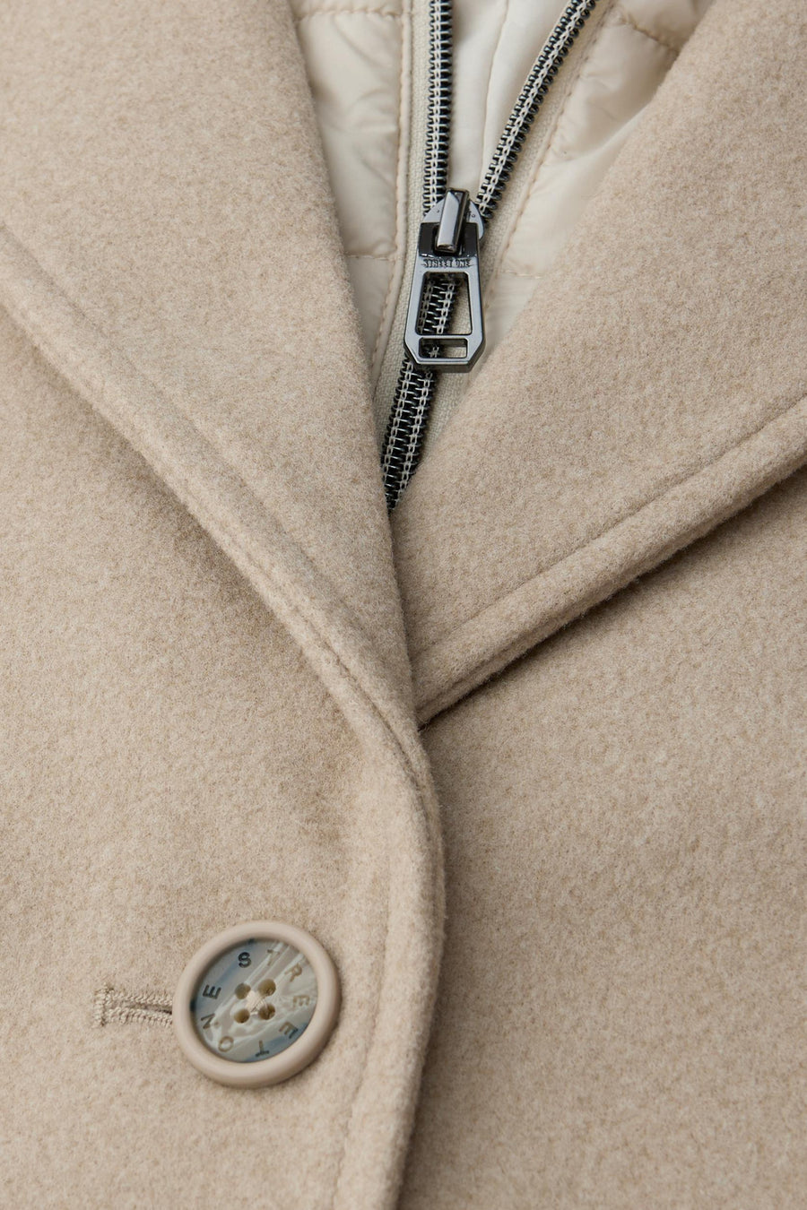 Lange beige jas van STREET ONE, met zilveren ritssluiting en knoop met logo-gravure.