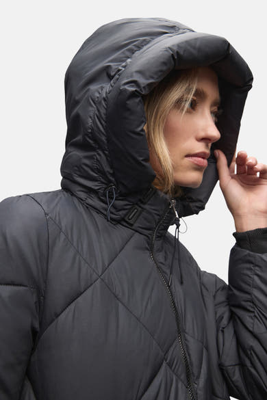 Veste longue bleue par Street One, avec un motif matelassé en losange et une capuche ample.