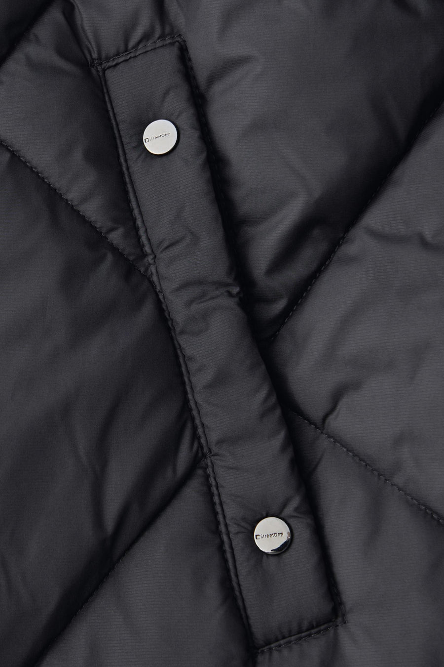 Veste longue noire par Street One, texture matelassée avec boutons argentés.