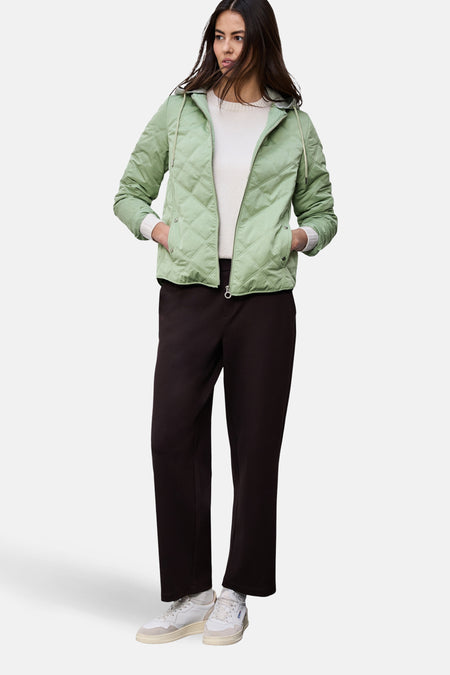Veste courte vert de STREET ONE, modèle matelassé avec capuche, portée avec un pantalon noir et des baskets blanches.