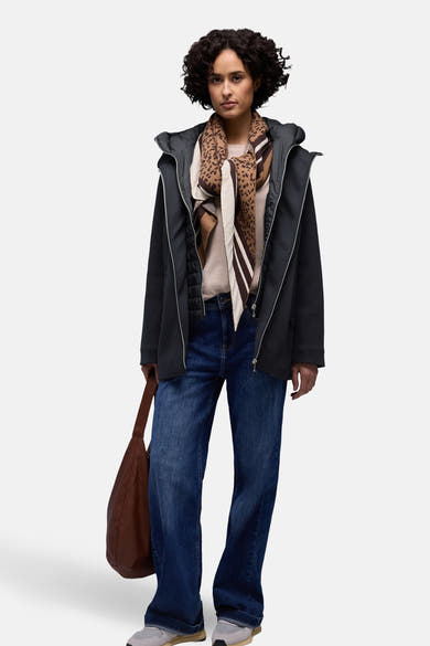 Veste courte bleu de STREET ONE, portée avec un foulard à motifs, un pull beige, un jean et un sac marron.
