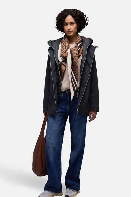 Veste courte bleu de STREET ONE, portée avec un foulard à motifs, un pull beige, un jean et un sac marron.
