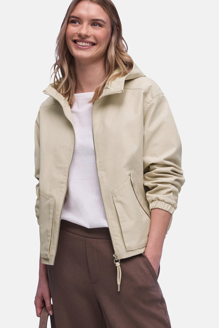 Veste courte beige de STREET ONE, portée sur un t-shirt blanc et un pantalon marron, avec une fermeture éclair.