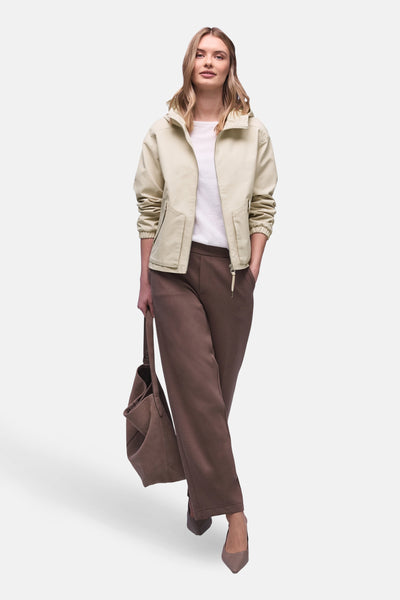Veste courte beige de STREET ONE portée avec un pantalon marron ample et un sac à main assorti.