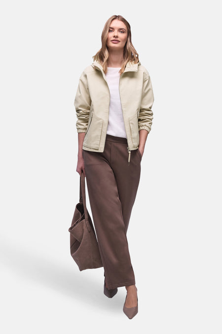 Veste courte beige de STREET ONE portée avec un pantalon marron ample et un sac à main assorti.