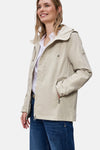 Veste courte beige de Street One avec une capuche et des poches zippées, portée sur une chemise blanche et un jean bleu.