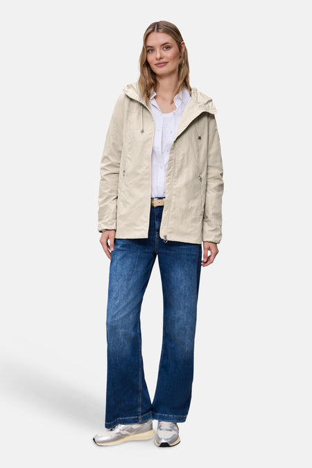 Veste courte beige de STREET ONE, portée avec une chemise blanche, un jean évasé bleu et des chaussures argentées.