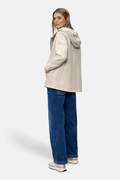 Veste courte beige de STREET ONE, avec capuche, portée avec un jean bleu ample et des baskets argentées.