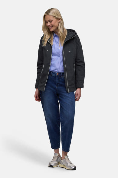 Veste courte bleue de STREET ONE, avec capuche, fermeture éclair argentée, portée sur une chemise bleue et un jean.
