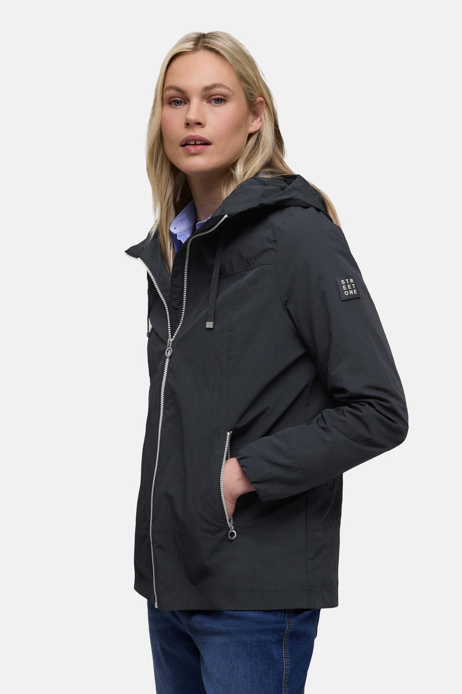 Veste courte bleue par STREET ONE avec capuche et fermeture éclair argentée, portée sur une chemise bleue.