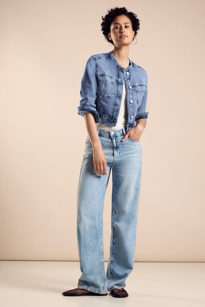 Veste en jean en denim bleu clair de Street One, portée sur un débardeur blanc et un jean bleu ample.
