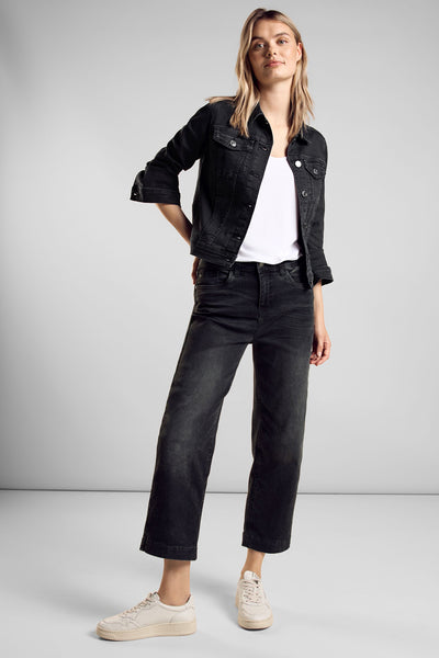 Veste en jean noire de Street One, portée sur un t-shirt blanc et un jean noir délavé.