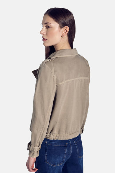 Korte beige jas van Street One met klassieke kraag en opgerolde lange mouwen, gedragen met een spijkerbroek.