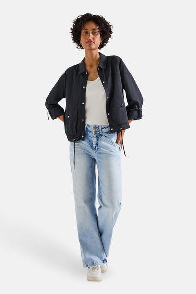 Kort blauw jasje van STREET ONE, gedragen met een witte tanktop en een wijde jeans.