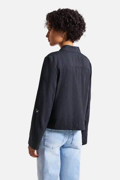Korte blauwe jas van STREET ONE, met lange mouwen en metalen details, gedragen met een lichtblauwe jeans.