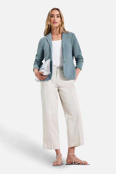 Blazer bleu de Street One avec une texture nid d'abeille, porté sur un débardeur blanc et un pantalon beige.