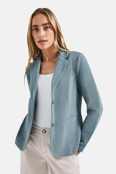 Blazer bleu texturé par Street One, porté avec un top blanc et un pantalon beige.
