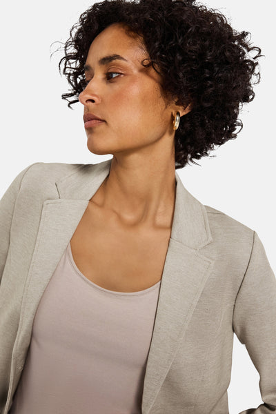 Beige blazer van STREET ONE, gedragen over een huidkleurige tanktop, met gouden oorbel.