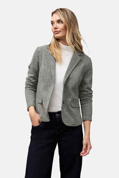 Grijze gemêleerde blazer van Street One, gedragen over een witte coltrui en een donkerblauwe jeans met omslag.