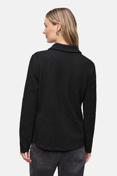 Blazer noir de STREET ONE, texture en maille, porté avec un jean gris et des boucles d'oreilles argentées.
