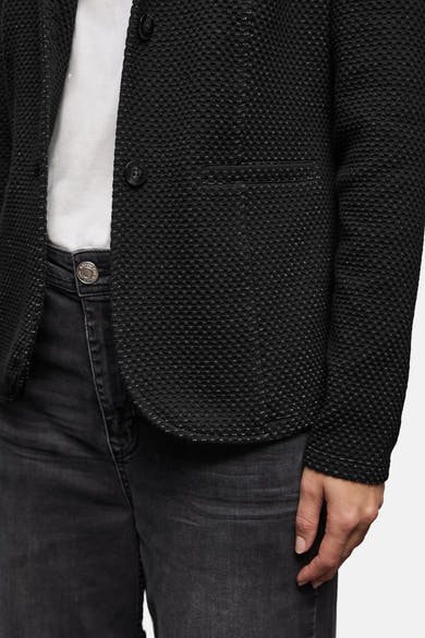 Blazer noir de STREET ONE avec un motif texturé subtil porté avec un jean gris délavé.

