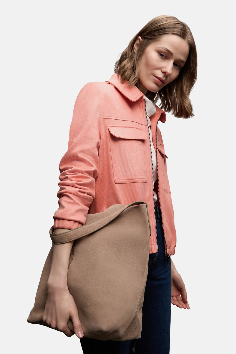 Veste courte corail Street One en velours côtelé, portée avec un jean bleu et un sac beige.