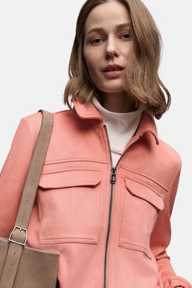 Veste courte corail de Street One avec fermeture éclair et poches plaquées, portée sur un col roulé blanc.