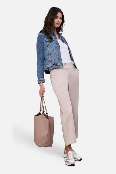 Veste en jean bleu délavé de Street One, portée sur un t-shirt blanc et un pantalon beige ample.