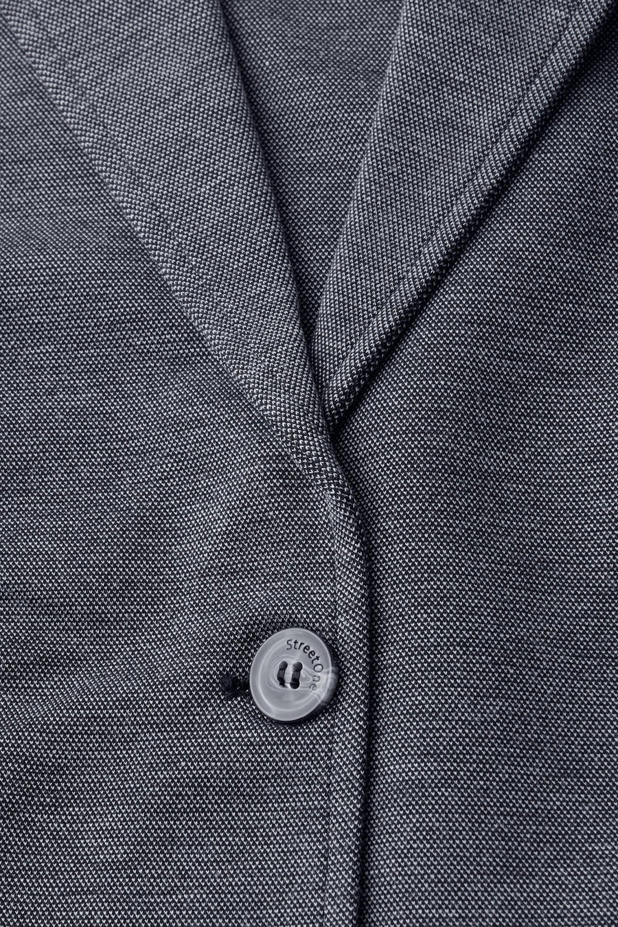 Gestructureerde blauwe blazer van STREET ONE met een ronde knoop met logo, close-up.
