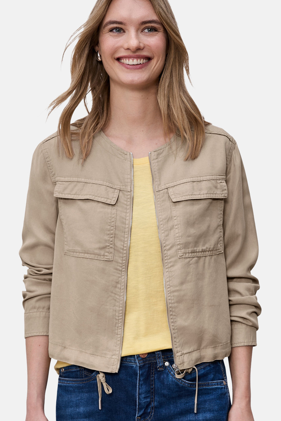 Beige overhemd met lange mouwen van Street One met borstzakken en ritssluiting over een geel T-shirt en een spijkerbroek.