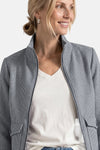 Blue houndstooth casual blazer with zipper front and notched collar, worn over white V-neck top, side view