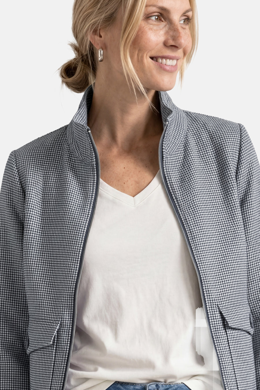 Blue houndstooth casual blazer with zipper front and notched collar, worn over white V-neck top, side view