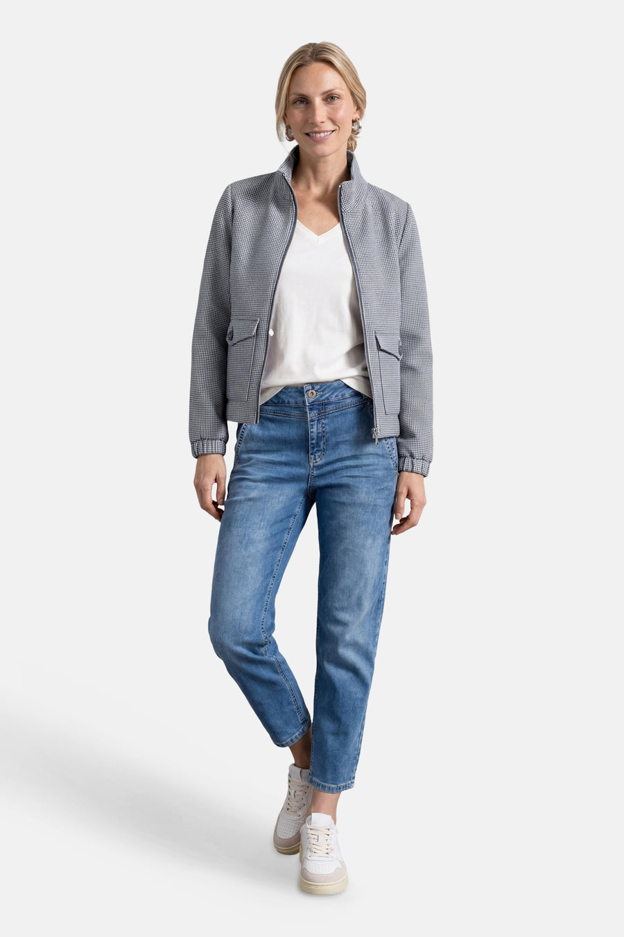 Blue houndstooth casual jacket with stand collar and front pockets, worn over white top with jeans and sneakers, full-length lifestyle view