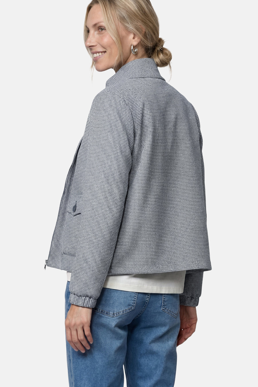Blue houndstooth pattern casual jacket from side view, featuring collar, button pocket, and cropped fit with model wearing white top and blue jeans.