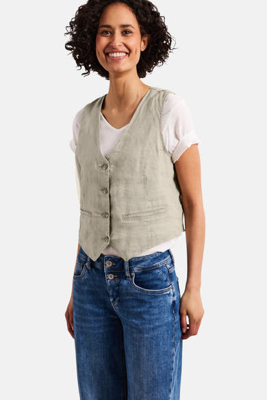 Beige mouwloze blazer van STREET ONE met knopen en kleine zakken, gedragen over een wit T-shirt en een blauwe jeans.