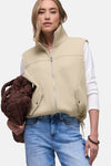 Beige gilet van STREET ONE, gedragen over een wit T-shirt met lange mouwen en een lichtblauwe jeans, met bruine tas.