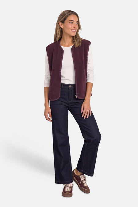 Gilet bordeaux en tissu doux par STREET ONE, porté avec un haut blanc, jeans larges et baskets marron, vue de face.
