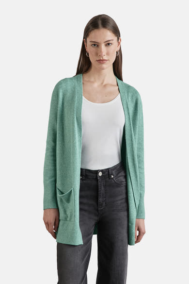 Groene cardigan van Street One, met opgestikte zakken, gedragen over een witte tanktop en een verbleekte zwarte jeans.
