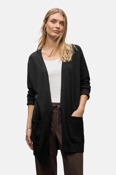 Gilet noir de Street One, porté avec un débardeur blanc et un pantalon marron à cordon.