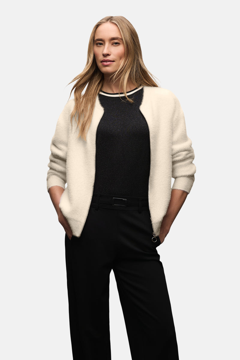 Ecru vest van STREET ONE, van pluizig breiwerk, gedragen met een zwarte broek en een zwart topje.