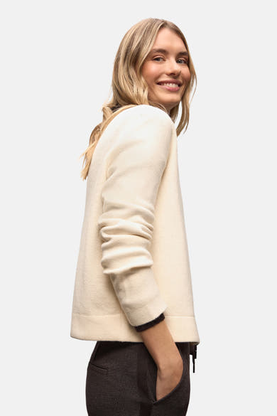 Ecru vest van Street One, met driekwartmouwen en gedragen over een antracietkleurige broek.