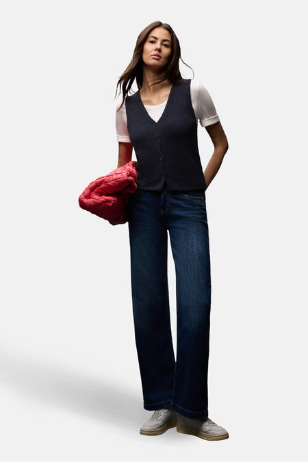 Débardeur bleu de STREET ONE, porté sur un t-shirt blanc, avec un jean bleu et un manteau rouge.
