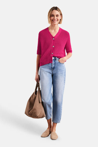 Gilet rose fuchsia en maille texturée de STREET ONE à manches courtes, col en V et boutons, porté avec un jean clair, des mules beiges et un sac en daim.