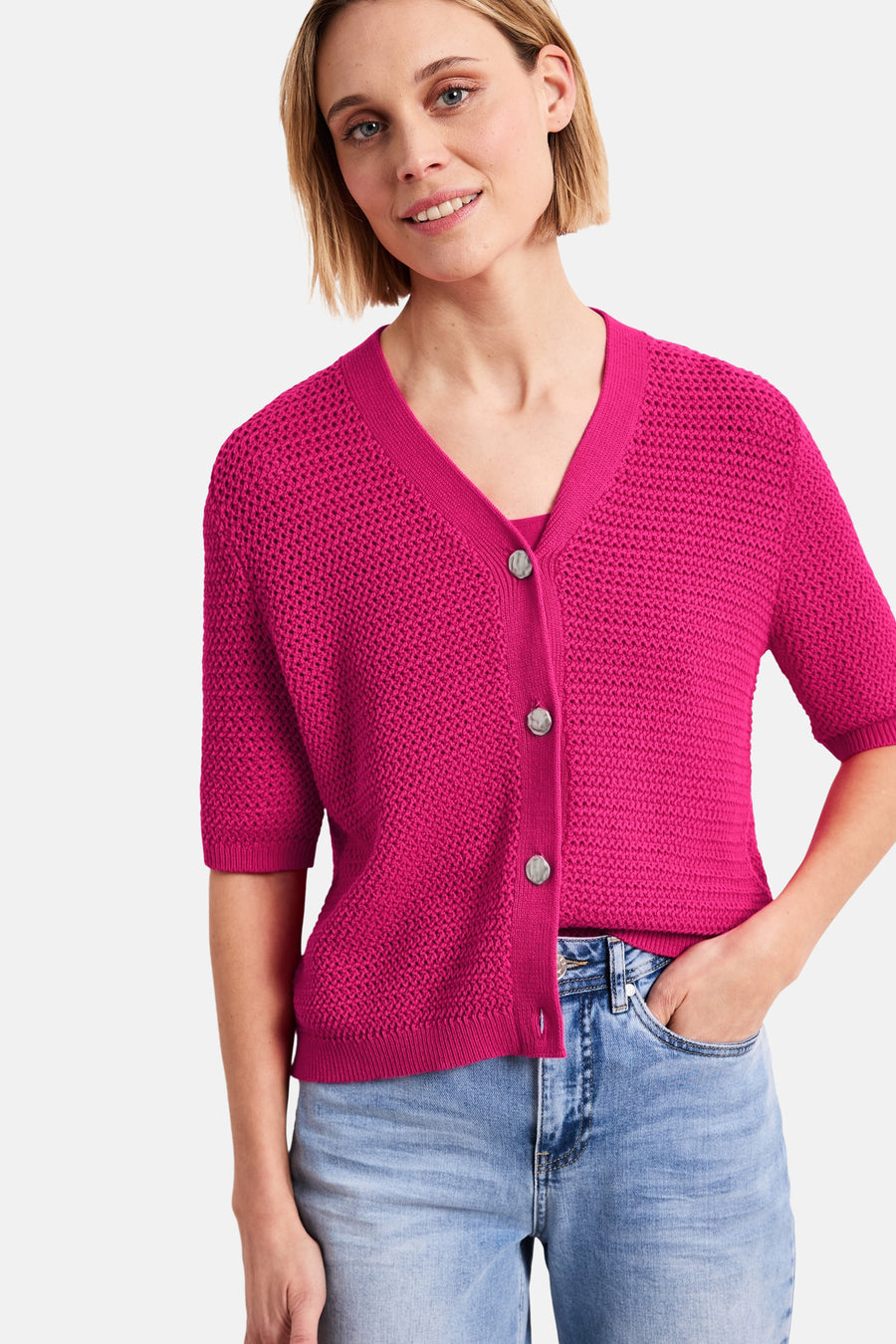 Roze vest van STREET ONE in ajourgebreide stof met V-hals, zilverkleurige knopen, 3/4 mouwen, gedragen met een spijkerbroek.
