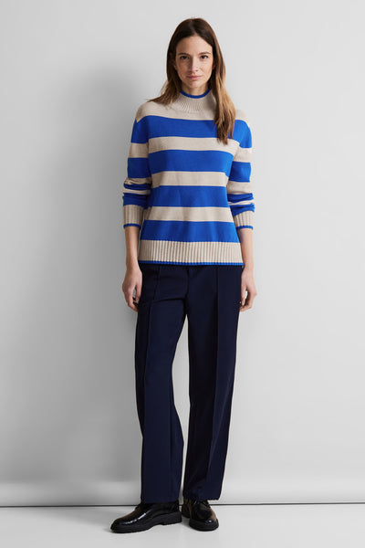 Pull à col roulé rayé bleu et beige de Street One, porté avec un pantalon bleu marine et des chaussures noires.