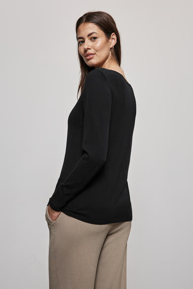 Zwarte rondehals trui van Street One, gedragen met een beige broek en gouden oorbellen.
