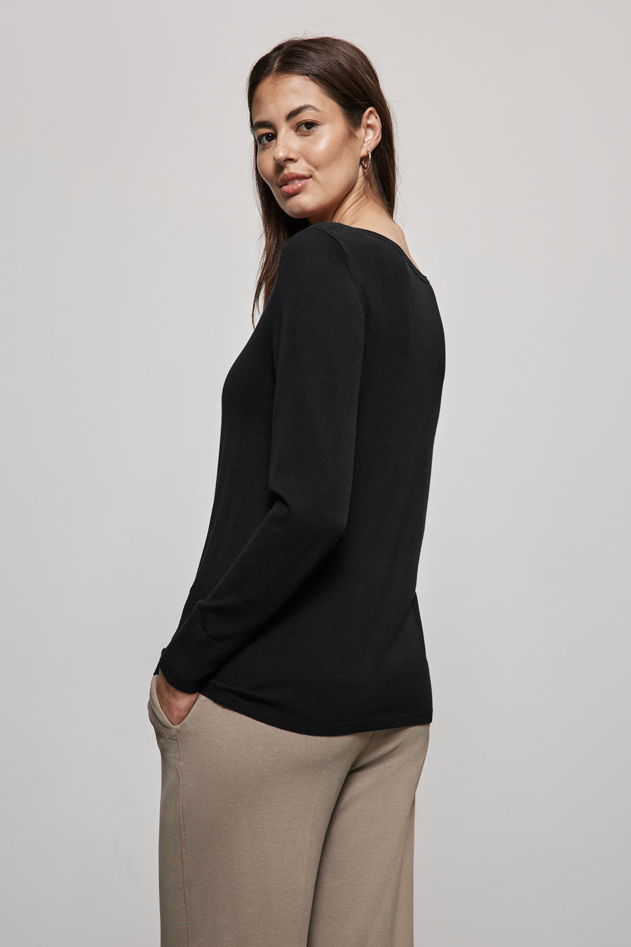 Zwarte rondehals trui van Street One, gedragen met een beige broek en gouden oorbellen.