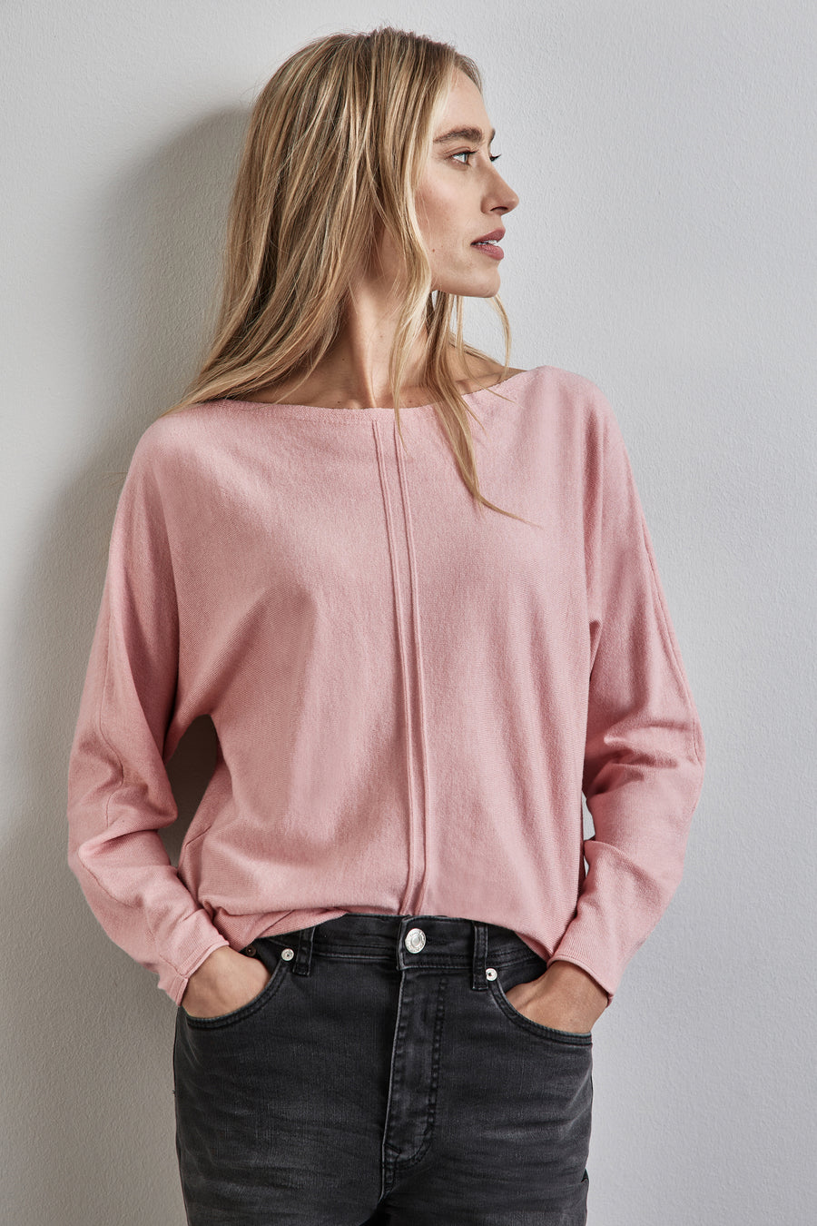 Roze trui met ronde hals van STREET ONE, gedragen met een zwarte broek en een geruite jas.