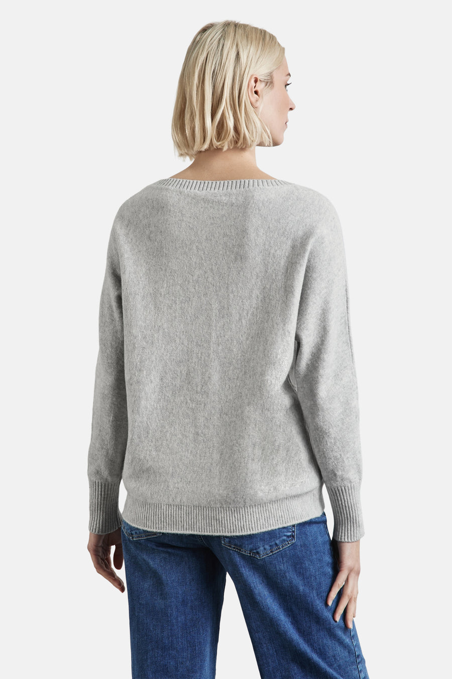 Grijze rondehals trui van STREET ONE, gebreid, gedragen met een blauwe jeans, achterzicht.
