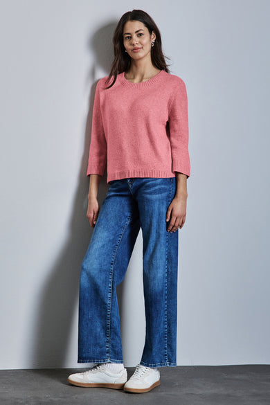 Pull à col rond rose de Street One, porté avec un jean ample bleu et des baskets blanches.